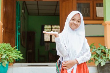primary student wearing school uniform showing something