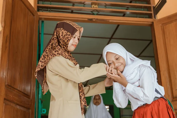 Potret murid sekolah islamik mencium tangan guru — Stok Foto