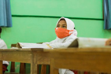 students studying in class using health masks