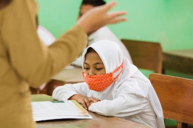 students studying in class using health masks