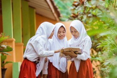 Indonesian school student reading a book together