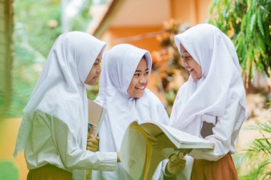 Indonesian school student reading a book together