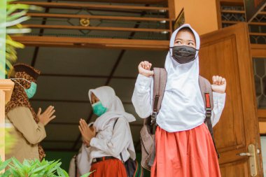 portrait of students saying goodbye to teachers with social distancing protocols