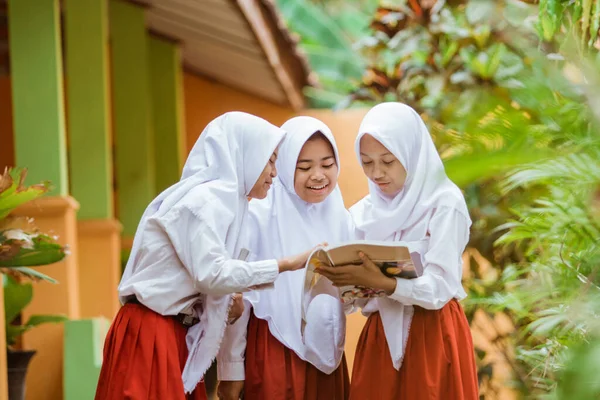 Estudante da escola indonésia lendo um livro juntos — Fotografia de Stock