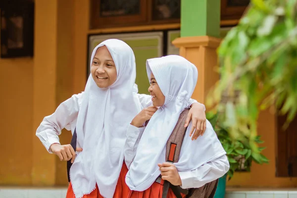 Potret dua siswa sekolah dasar mengenakan seragam sekolah tertawa canda — Stok Foto