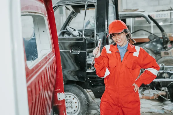 Porträtt av en ung kvinna som arbetar som bilmekaniker — Stockfoto