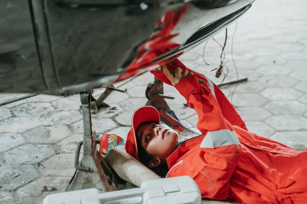 Portrait of young woman repairing a broken car engine part — Stock Photo, Image