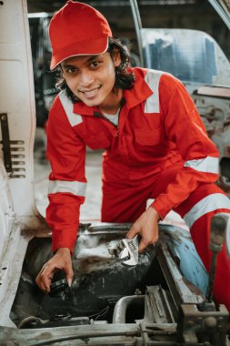 man repairing a broken car engine part