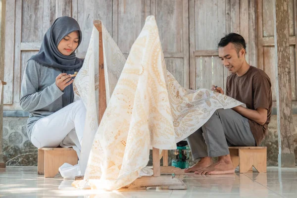 Wanita muda dan pria menggambar batik — Stok Foto