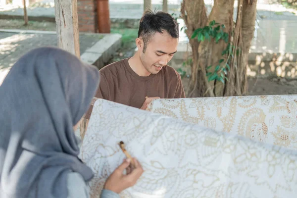 Young woman and man drawing batik — Stock Photo, Image