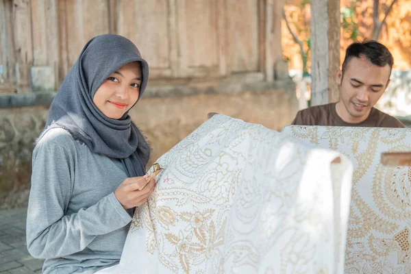 Wanita muda dan pria menggambar batik — Stok Foto