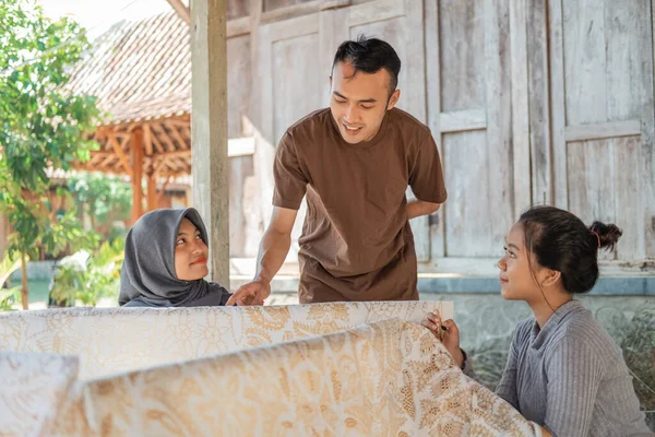 Potret pria memeriksa hasil batik pada kain putih — Stok Foto