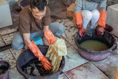 a portrait of a workers work in cloth coloring process