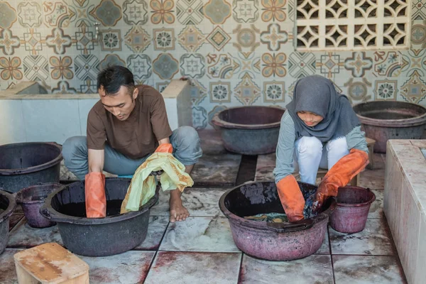 a portrait of a workers work in cloth coloring process