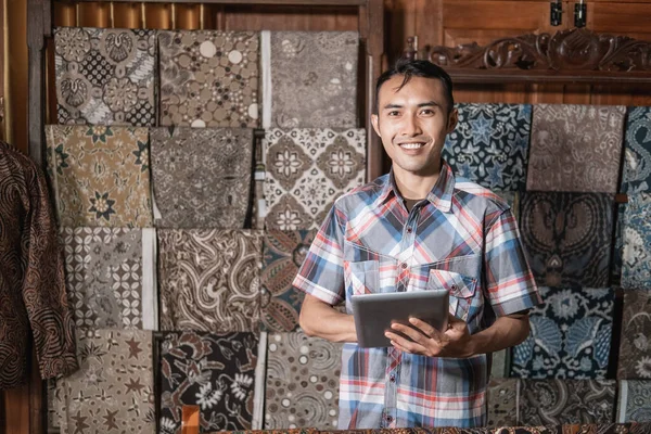 Retrato de jovem atendimento ao cliente na loja batik — Fotografia de Stock