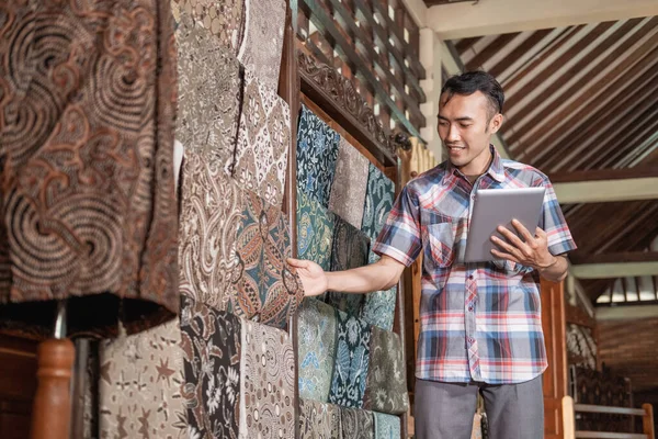 Porträt junger Männer, die traditionelle Batik prüfen — Stockfoto