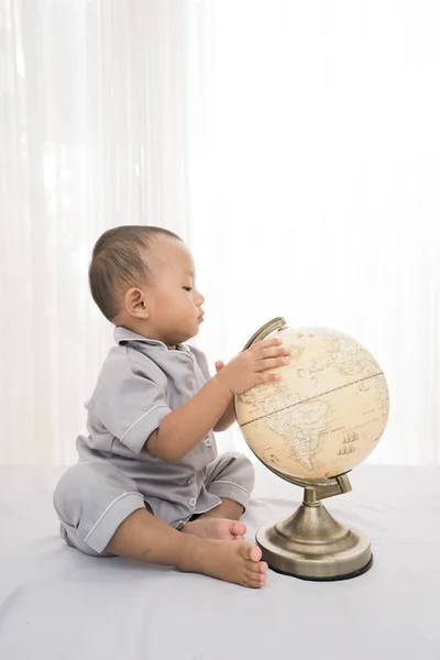 Retrato feliz de um menino adorável jogando globo — Fotografia de Stock