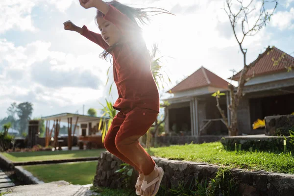 Mała dziewczynka cieszyła się gry skok w ogrodzie — Zdjęcie stockowe