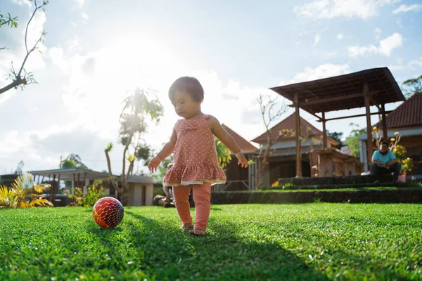 Маленькая девочка любила играть в мяч на заднем дворе — стоковое фото