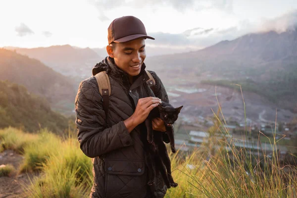 Portrait adventurous man with a backpack captures the moment with cat. — Stock Photo, Image