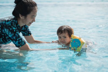 Çocuğuna eğitim veren bir annenin portresi.