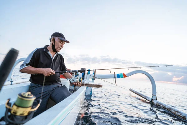 Porträt eines jungen Fischers, der auf einem Boot fischt — Stockfoto