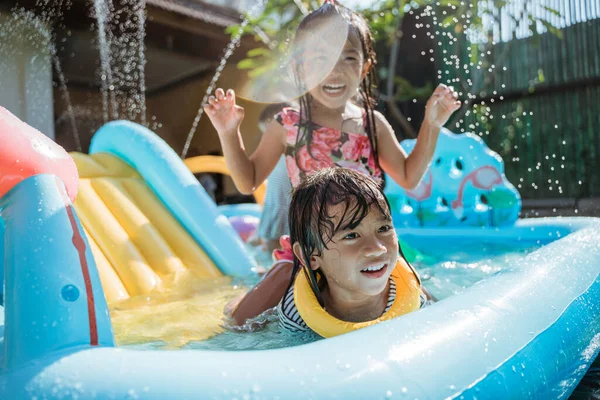 Children very happy playing water slide — Stock Photo, Image