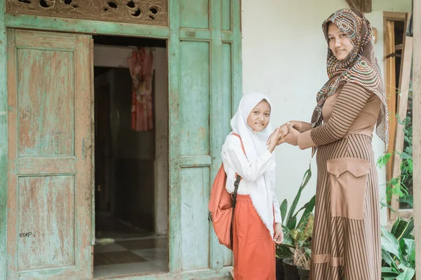 Siswa muslim berjabat tangan dan mencium tangan ibunya sebelum pergi ke sekolah — Stok Foto