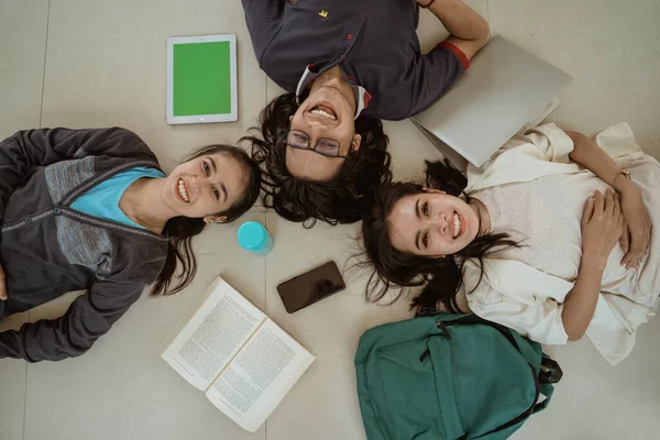 Ritratto divertente studenti sdraiati a lavorare in gruppo — Foto Stock