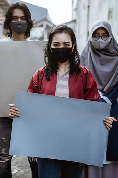 Estudiantes de retrato sosteniendo papel en blanco realizando demostraciones — Foto de Stock