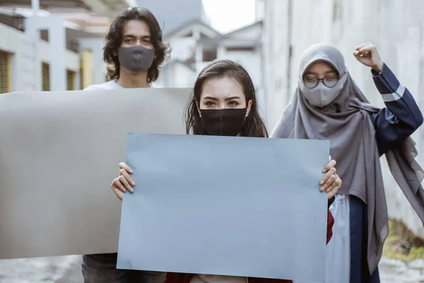 Portrétní studenti držící prázdný papír dirigování demonstrace — Stock fotografie