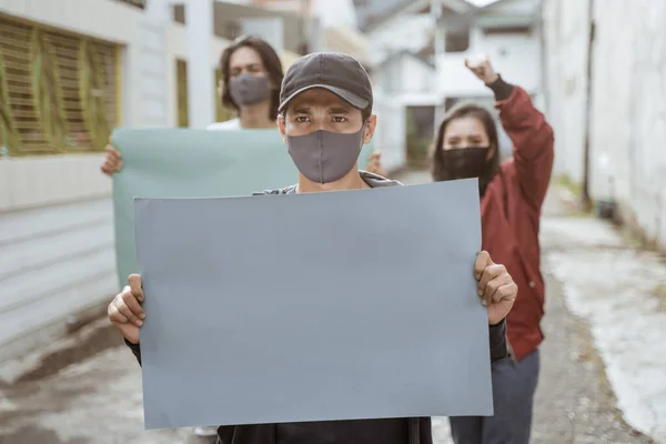 Estudiantes de retrato sosteniendo papel en blanco realizando demostraciones — Foto de Stock