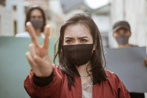 Portret vrouwelijke studenten demonstreren met hun vrienden houden blanco papier op de achtergrond — Stockfoto