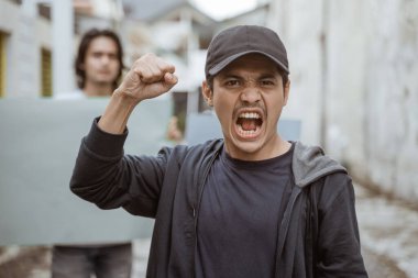 Elinde boş kağıtlarla coşkuyla yanan erkek öğrencilerin portresi.