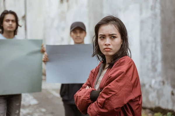 Portret vrouwelijke studenten kruisen hun armen demonstreren met hun vrienden — Stockfoto