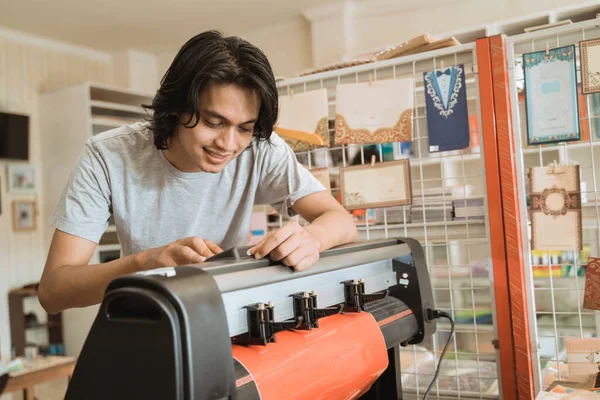 Jovem empresário masculino Fazendo papel autocolante por máquina — Fotografia de Stock