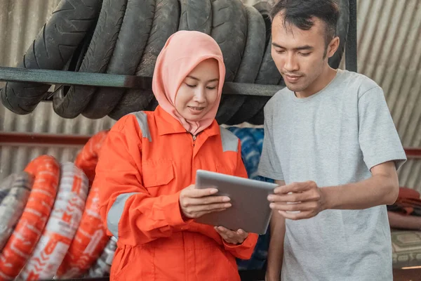 Mujeres veladas que usan uniformes de wearpack que muestran tabletas digitales a los consumidores —  Fotos de Stock