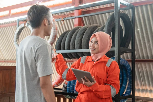 Velado asiático mujer mecánico utiliza un digital tableta mientras charlando con los consumidores masculinos de pie —  Fotos de Stock