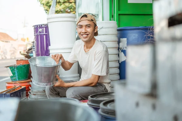 Male seller smiling when look at camera while holding a bucket — Stock Photo, Image