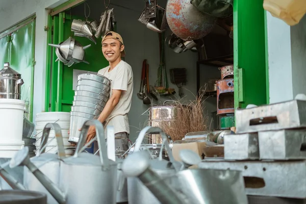 Ásia masculino sorrindo enquanto carregando lotes de baldes — Fotografia de Stock