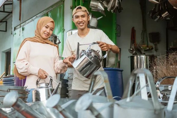 Мужчина торгует традиционными чайниками для азиатских женщин — стоковое фото
