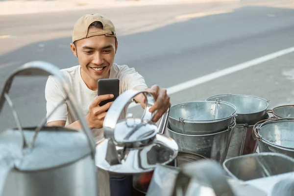 Nahaufnahme von asiatischen männlichen Verkäufer hocken mit Handykamera beim Fotografieren eines Wasserkochers — Stockfoto