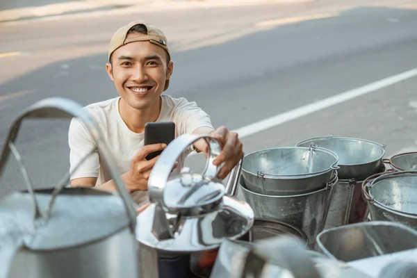 Nahaufnahme eines lächelnden männlichen Verkäufers mit Handykamera beim Fotografieren eines Wasserkochers — Stockfoto