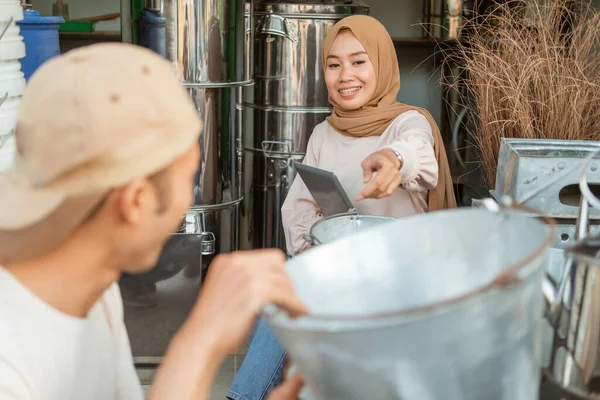 Muslimka pomocí tabletu s ukazováčkem pro výběr kbelíku s asistentem — Stock fotografie