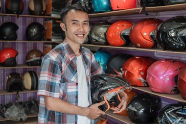 Kask tutarken gülümseyen adam