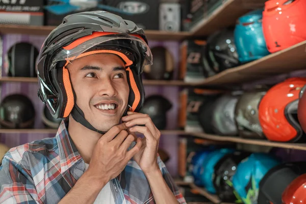 Man smiles hooking buckle strap while wearing helmet — Stock Photo, Image