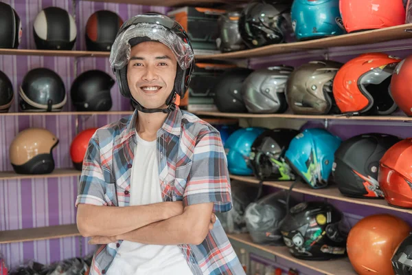 Uomo sorridente che indossa casco con le mani incrociate — Foto Stock