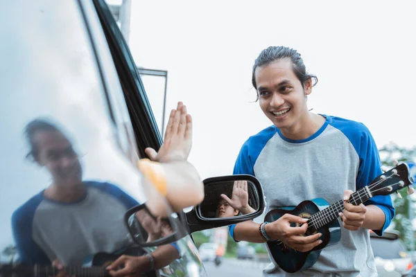 Busker χρησιμοποιώντας ένα μουσικό όργανο και το τραγούδι απορρίφθηκε από κάποιον από το αυτοκίνητο — Φωτογραφία Αρχείου