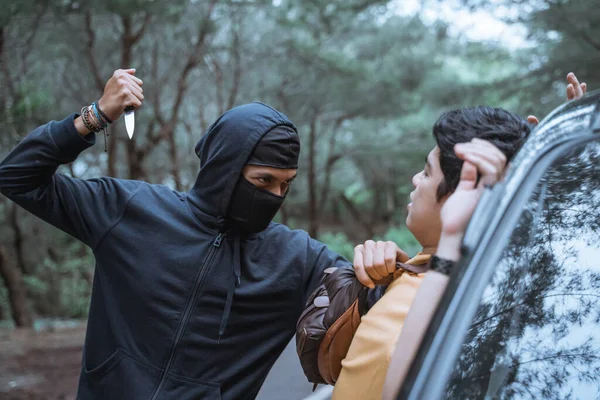 Robber in a mask use a sharp weapon want to kill the victim — Stock Photo, Image