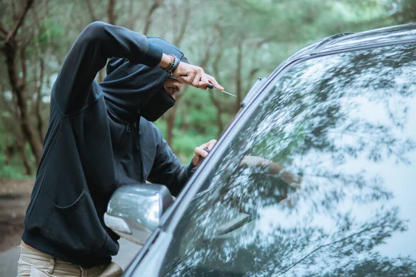 Crimineel draagt zwart in de straat met mes in de buurt van auto — Stockfoto